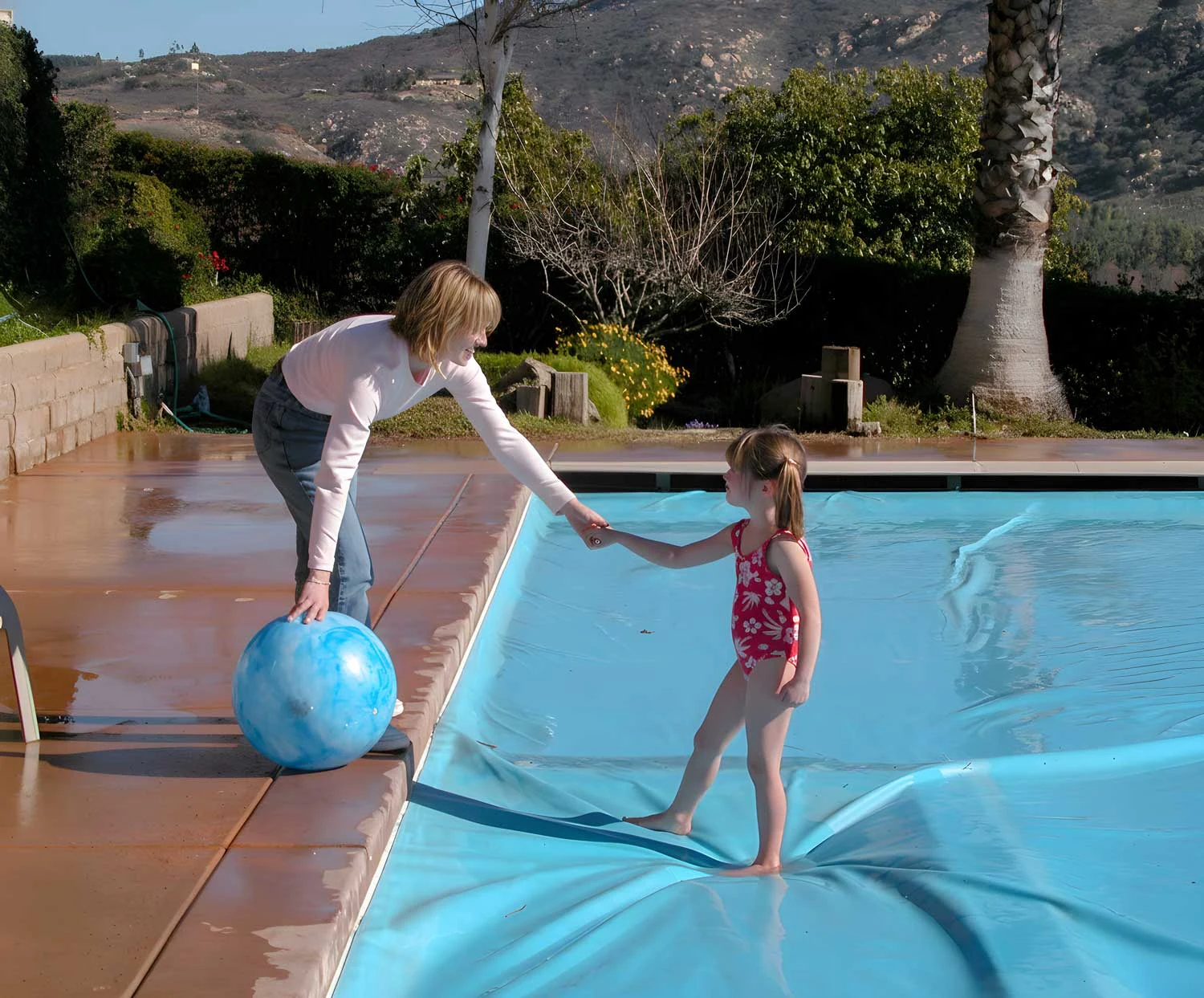 Coverstar demonstration showing a mother helping her child off a closed safety cover